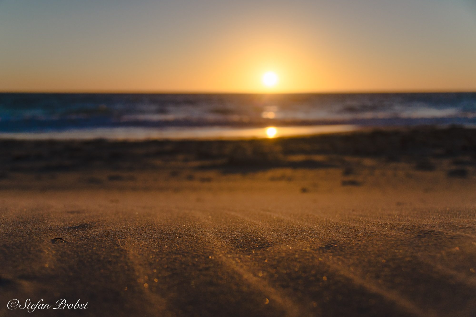 Wellen im Sand bei Sonnenuntergang