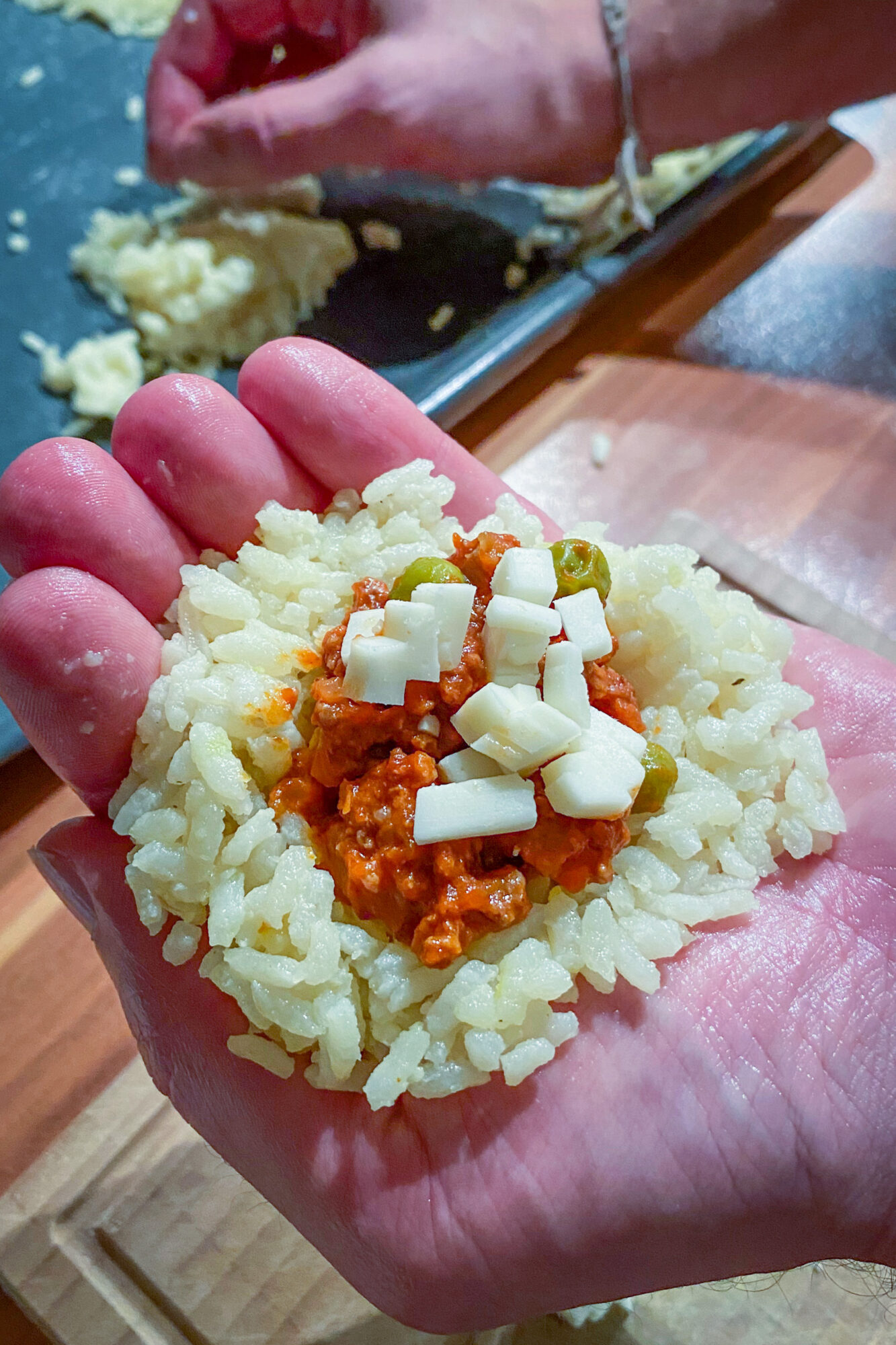 Arancini - Reis wird in der Hand gefüllt