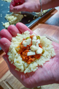 Arancini - Reis wird in der Hand gefüllt