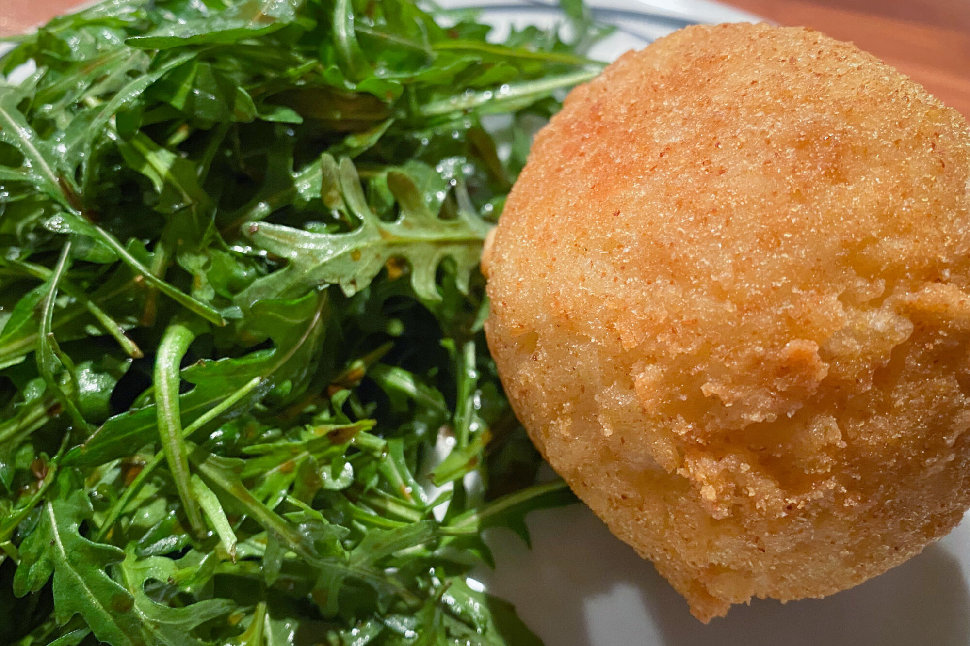 Arancini angerichtet mit Rucolasalat