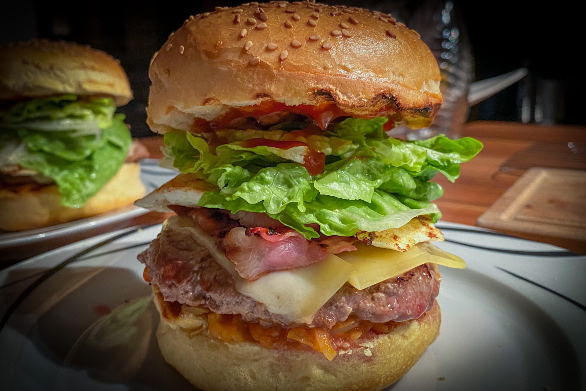 Burger mit Rinderpatty, Speck, Käse, Spiegelei und Salat